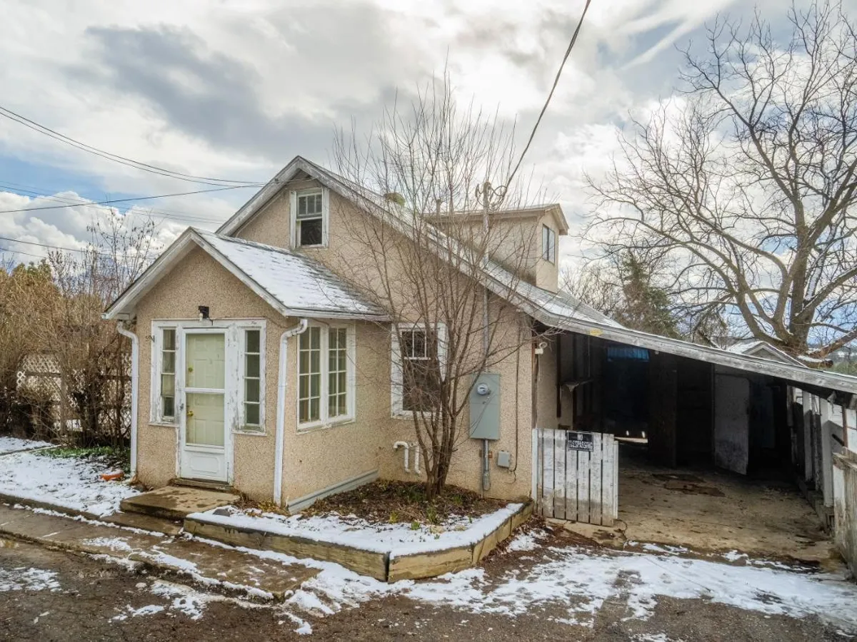 A weathered stucco character home needing renovation