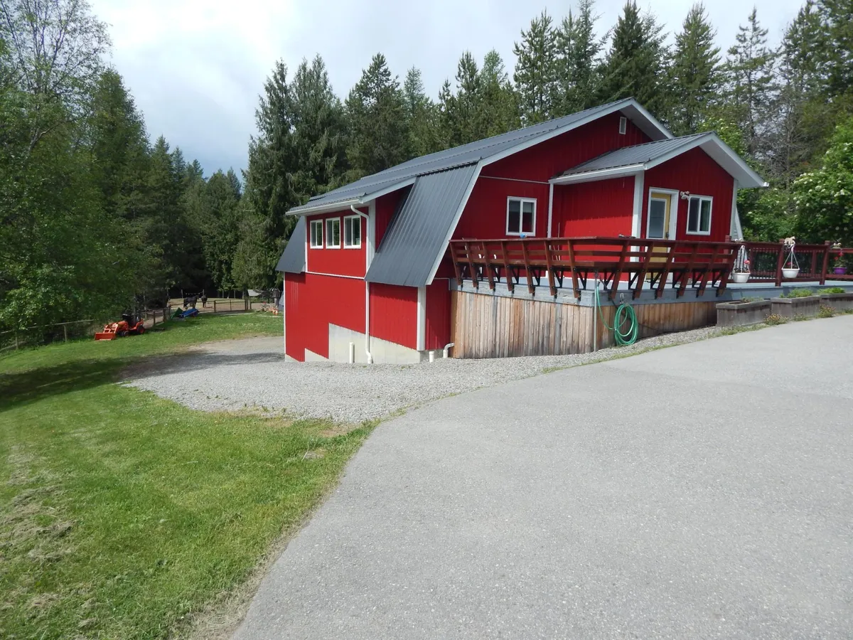 A red barn-style home with a paddock on acreage